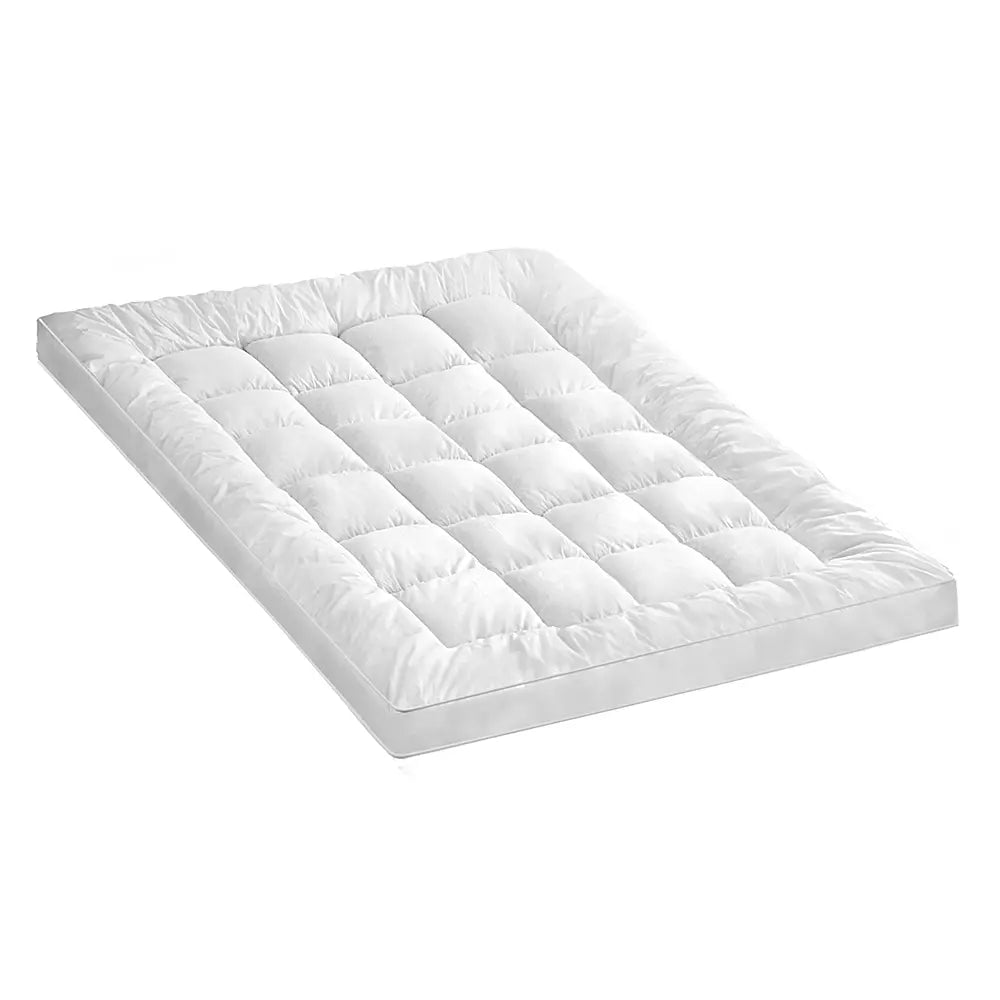Zoilo Cotton Mattress Topper in White on a neatly made bed