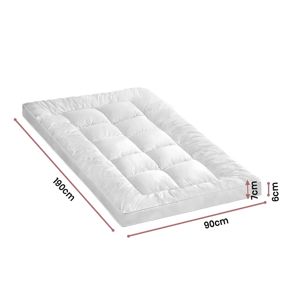 Front-facing view of the Zoilo Mattress Topper in a cozy bedroom with white bedding