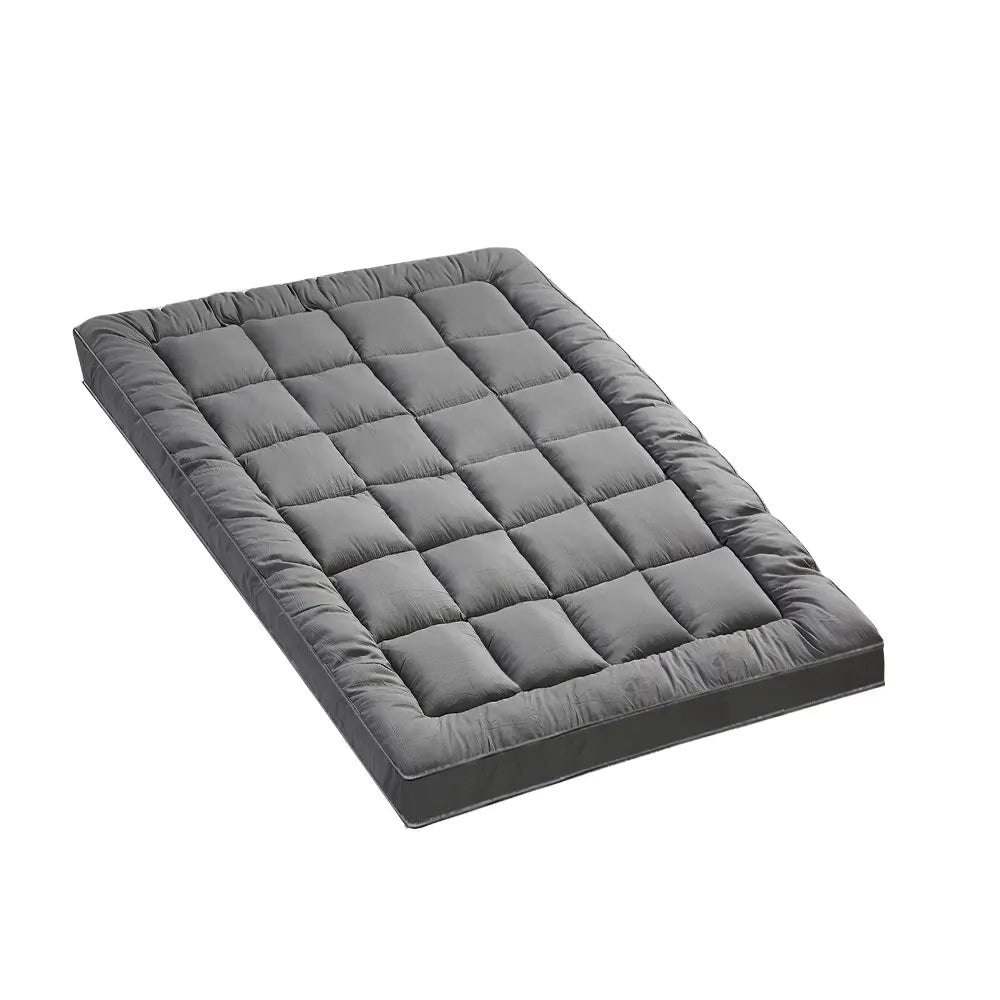 Zoilo Cotton Mattress Topper in Grey on a neatly made bed