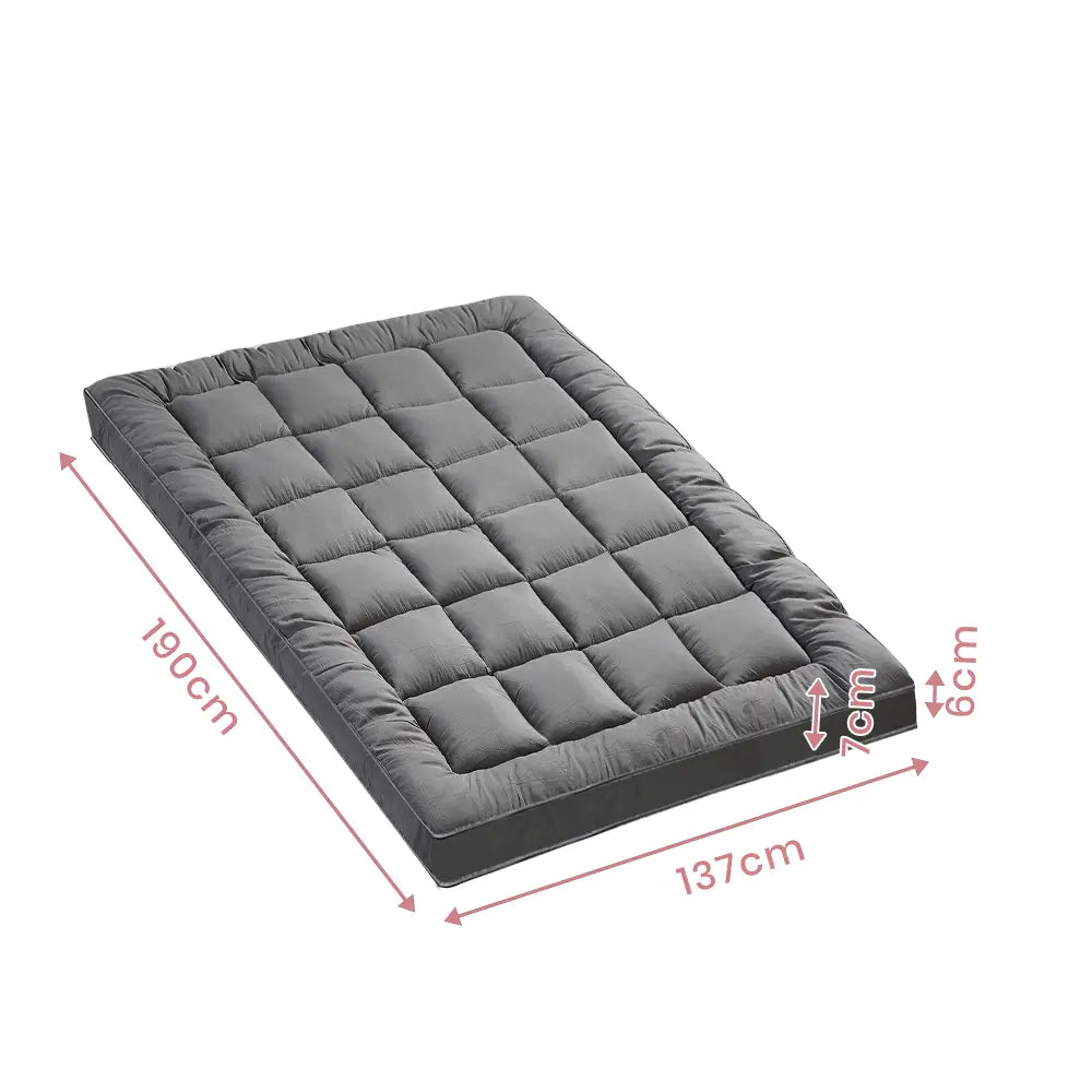 Front-facing view of the Zoilo Mattress Topper on a modern bed with grey bedding