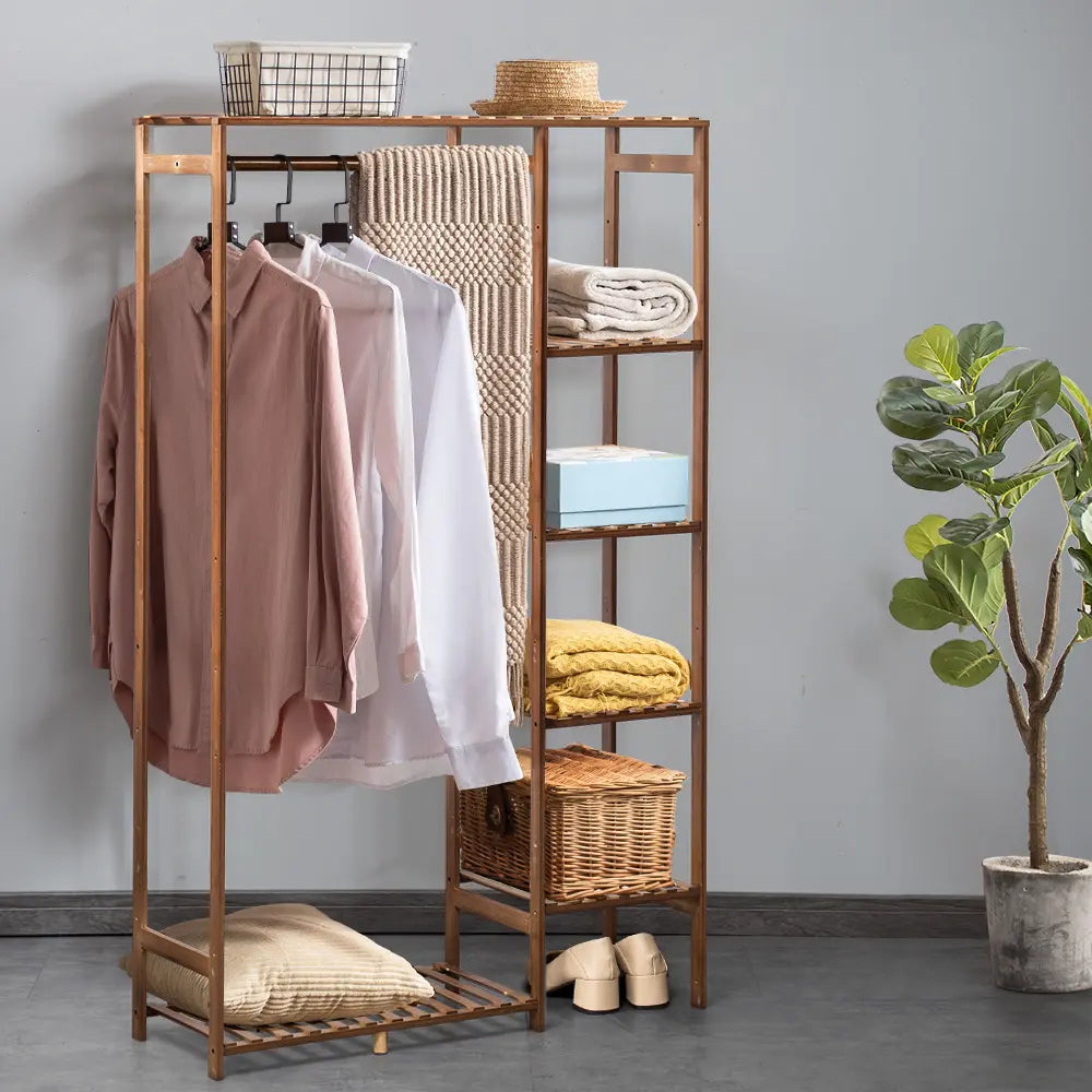 Guerrero wooden garment rack with hanging clothes in a bedroom